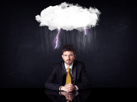 53337200 - depressed businessman sitting under a lightning rainy cloud