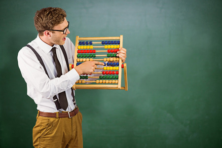 44598197 - geeky businessman using an abacus against green chalkboard